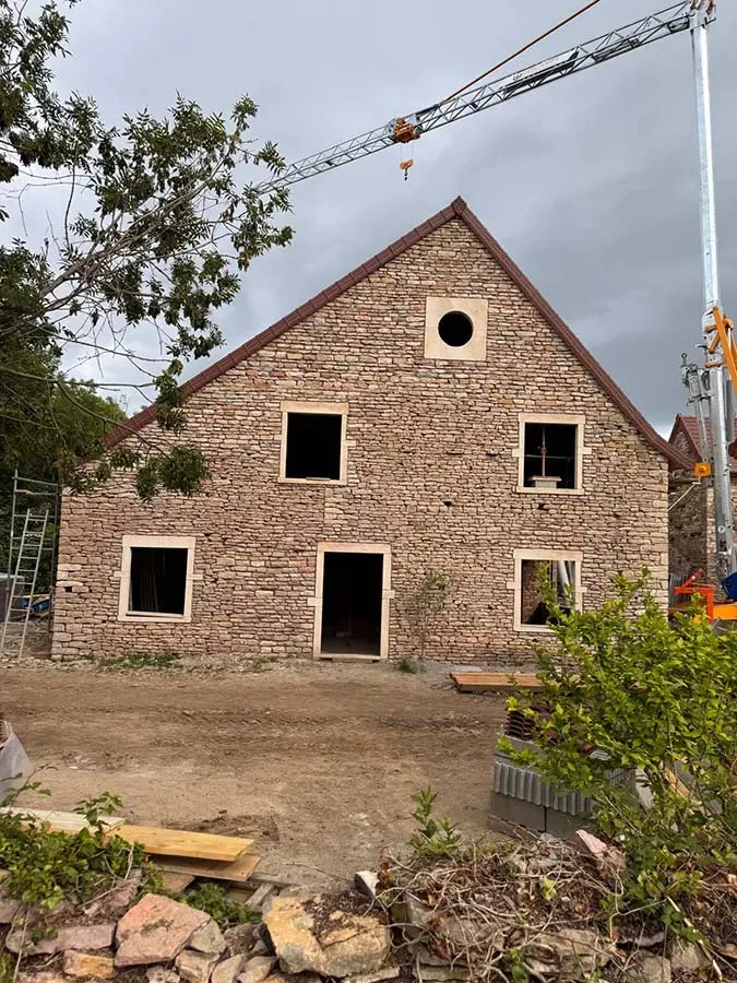 Maison en pierre et grue blanche